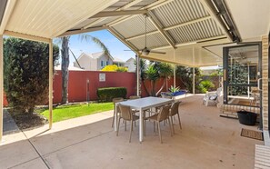 A covered patio with a table and chairs, a small pool, and a view of the neighborhood. - Chiton Rocks Court! Mini Oasis by the Sea (Chiton)
