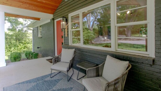 A covered patio with two wicker chairs and a blue patterned rug. - Cute And Cozy - Historic Franklin Quadplex (Franklin)