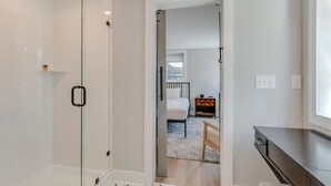 Une salle de bain moderne avec une douche à parois de verre et des toilettes apparentes.