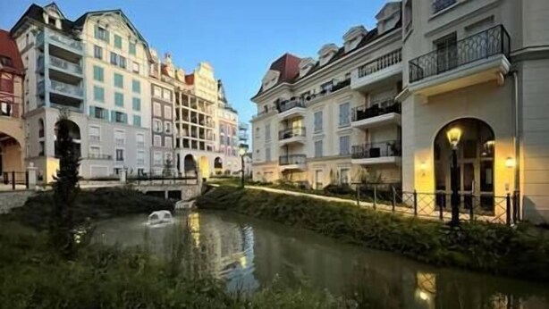 A canal with buildings on either side, featuring balconies and arched windows.