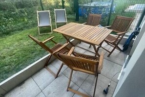A balcony with a wooden table and four chairs. - Le Plessis-Capitale: Apartment with a private garden (Le Plessis-Robinson)