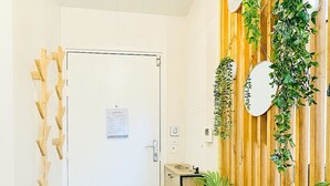 A hallway with a wooden wall, a white door, and a potted plant.
