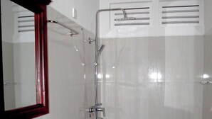 A bathroom with a white sink, a toilet, and a shower. - The Cave Kithulgala (Kithulgala)