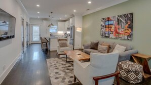 A modern apartment with a kitchen, dining area, and living room.