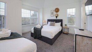 A modern bedroom with a large bed, two bedside tables, a desk, and a wardrobe. - Two Spectacular Homes- 20 Guests - Outdoor Patio (Nashville)