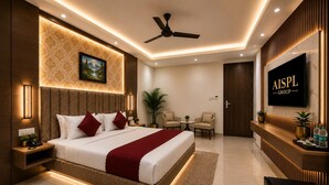 A modern hotel room with a large bed, a flat-screen TV, a ceiling fan, and a reception desk. - Airport Hotel Platinum (New Delhi)