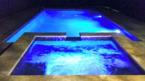 A rectangular pool with a blue-lit edge and a waterfall feature in the center.
