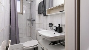 Un baño moderno con ducha, inodoro y lavamanos.