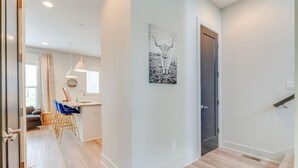 A modern apartment with a dining area, a kitchen, and a staircase.
