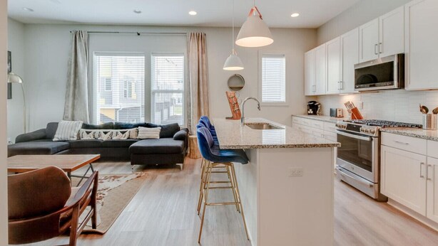 A modern apartment with a living room, kitchen, and dining area.