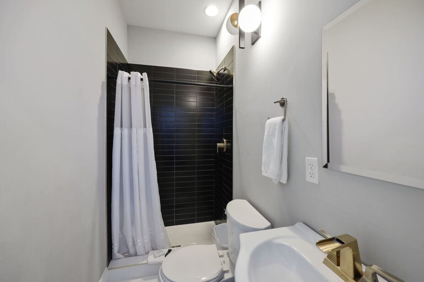 Un baño moderno con ducha, inodoro y lavamanos.