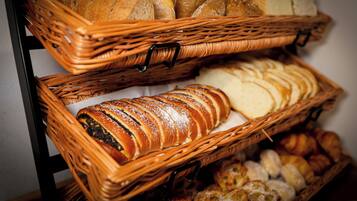 Two wicker baskets filled with various breads and pastries.