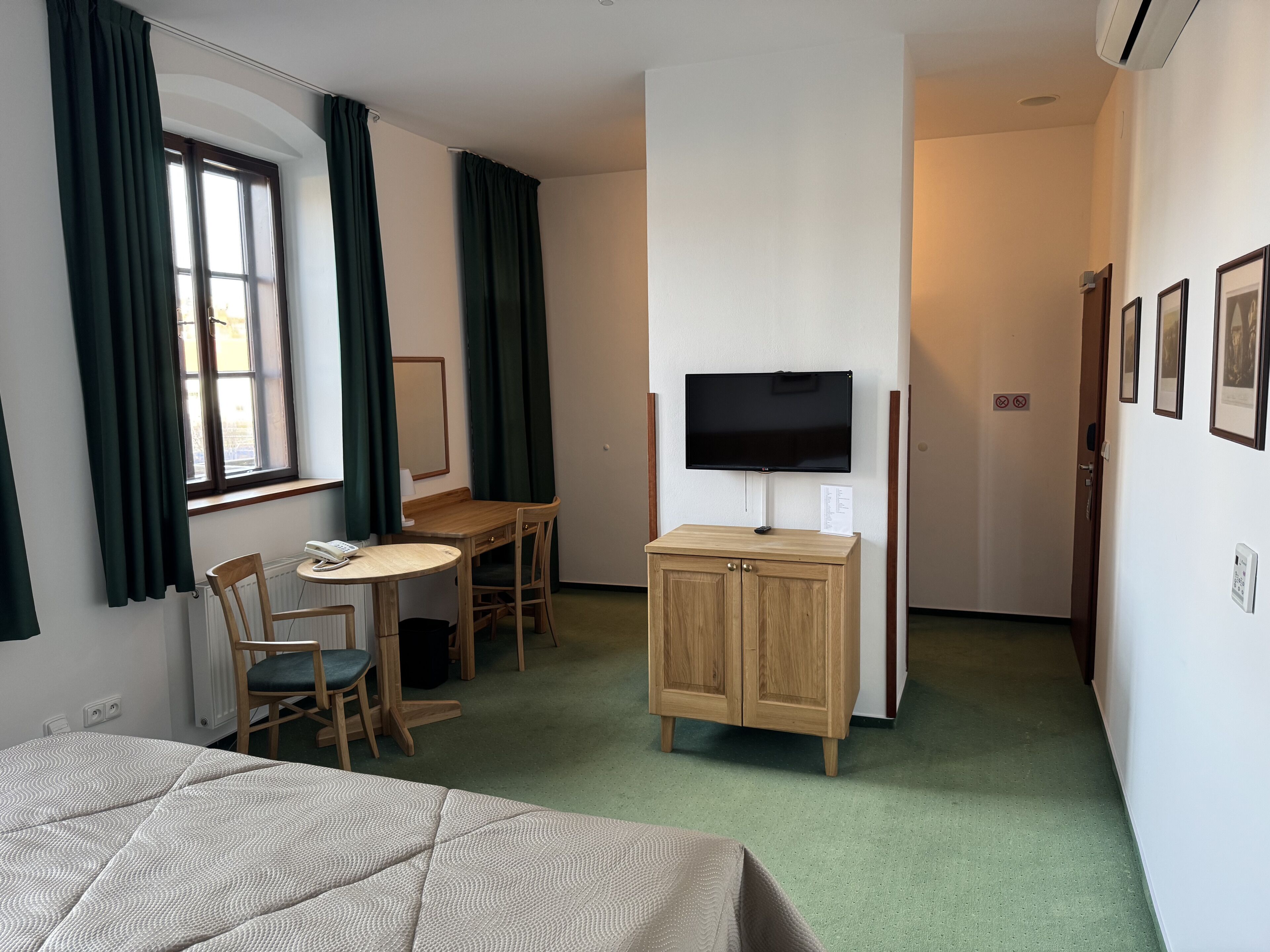 Une chambre d’hôtel comprenant un lit, un bureau, une chaise, une télévision et un placard.