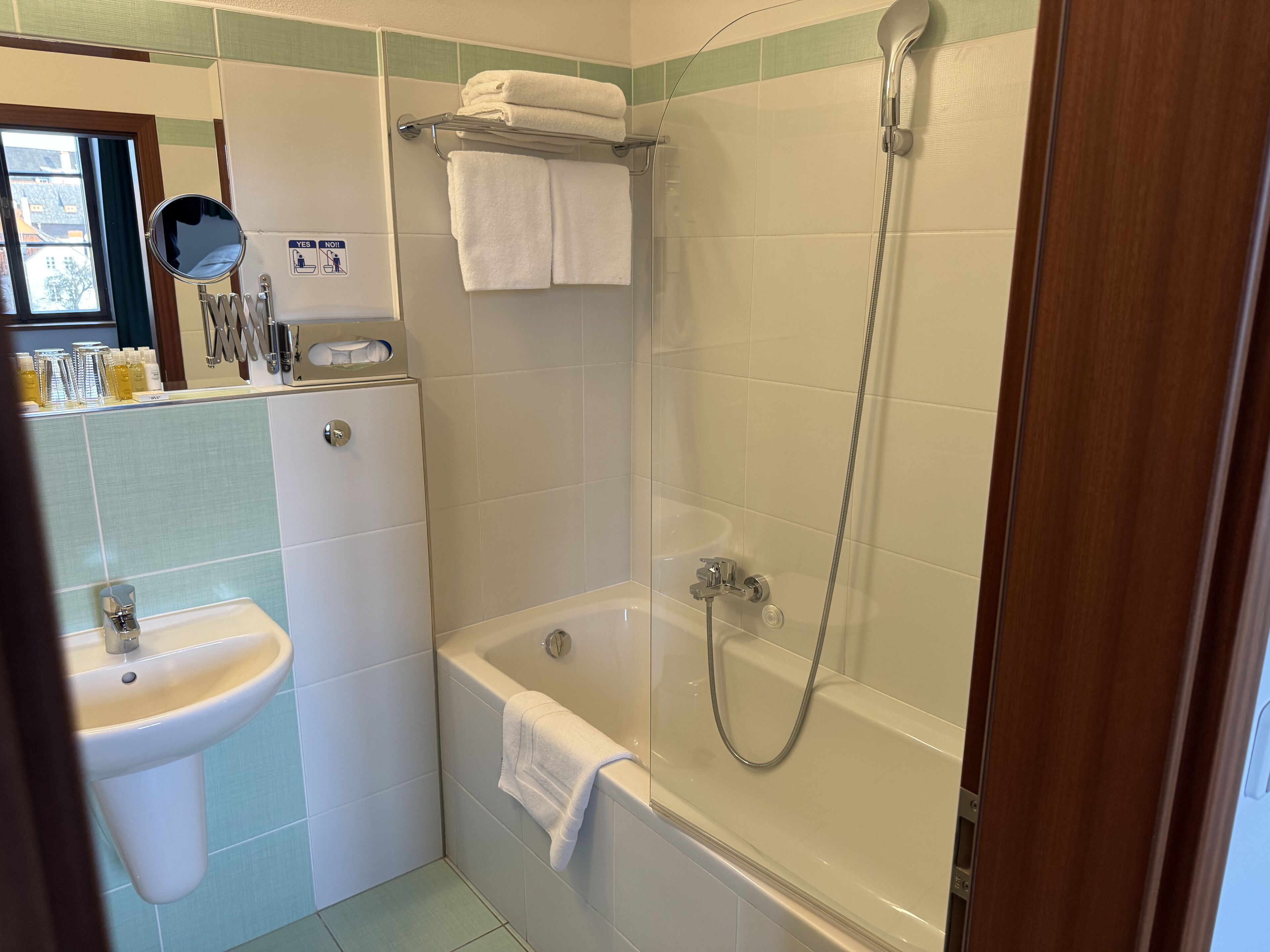 Een badkamer met een wastafel, een bad en een douche.