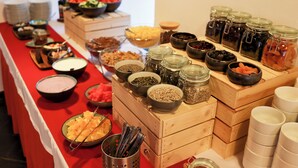 Una mesa de buffet con diversos alimentos y aderezos.