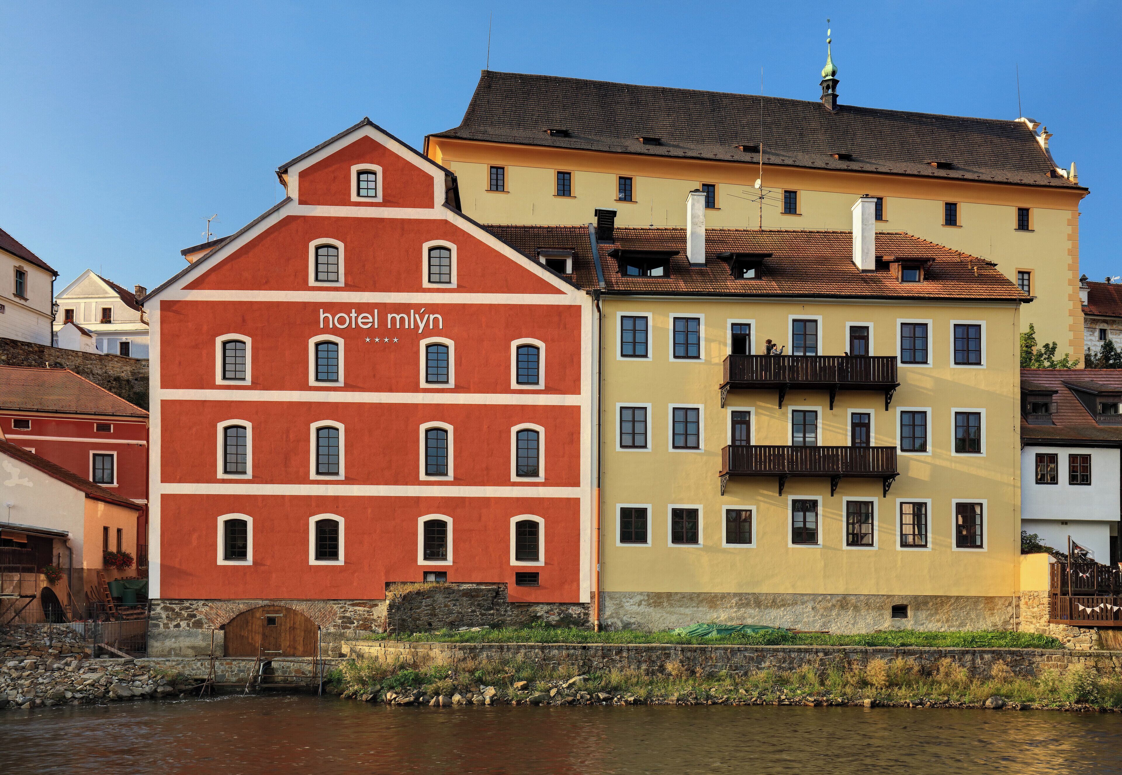 A hotel with a red facade and a yellow building adjacent to it.