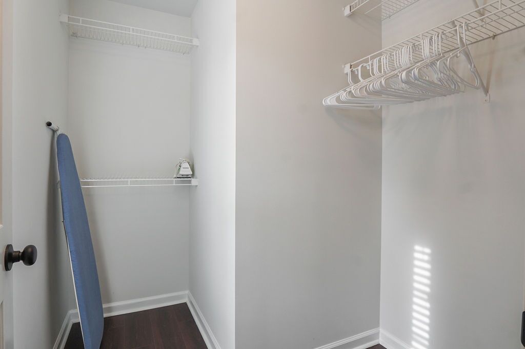 A laundry room with metal drying racks and shelves.