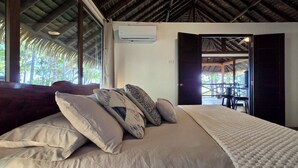 Une chambre à coucher avec un lit, des oreillers et un appareil de climatisation.