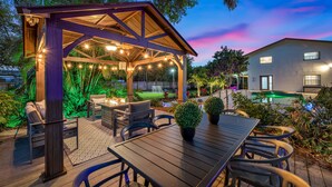 Eine Außenpatio mit Holz-Pergola, Sitzgelegenheiten und einem Poolbereich.