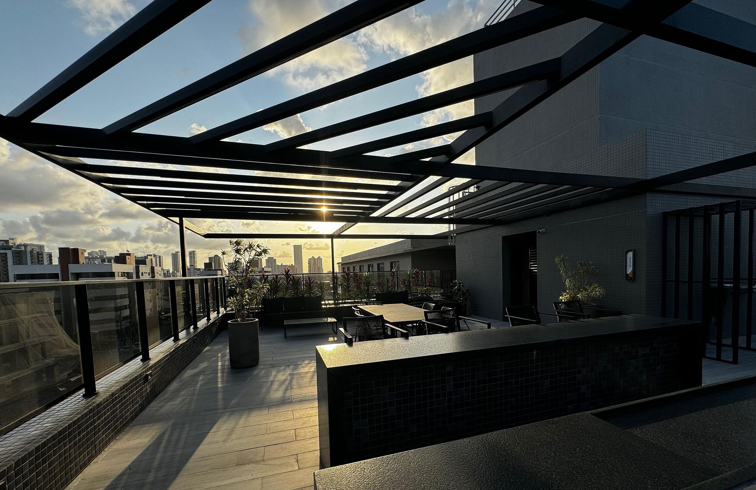 Una terraza en la azotea con diseño moderno, que incluye una zona de estar y vistas al horizonte urbano.