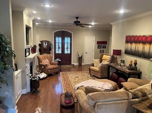 Cozy living room with a fireplace, comfortable seating, and a beautiful painting.