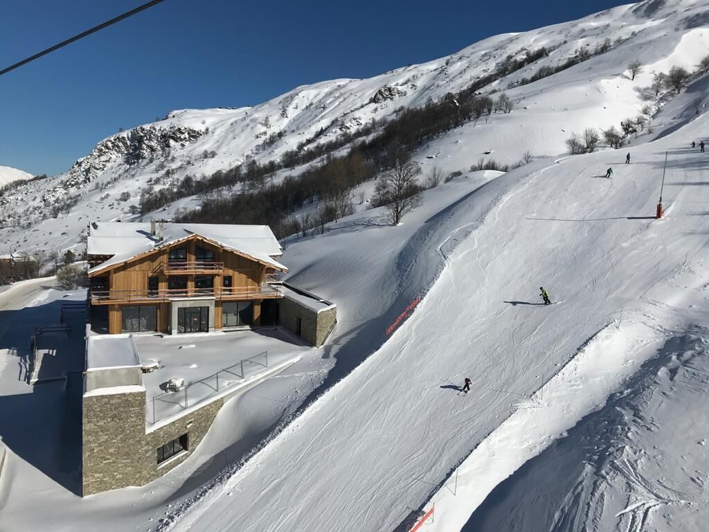 A ski resort with a lodge featuring a wooden exterior and a stone foundation.