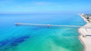 A coastal view with a long pier extending into the ocean, a sandy beach, and a cityscape in the background. - Ask About Winter DEALS-Private HEATED Pool-3 Miles to 30A-Pet Considered! (Panama City Beach)