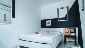 A bedroom with a bed, a chair, and a wall-mounted picture frame. - Pousada Cambará (Tamandaré)