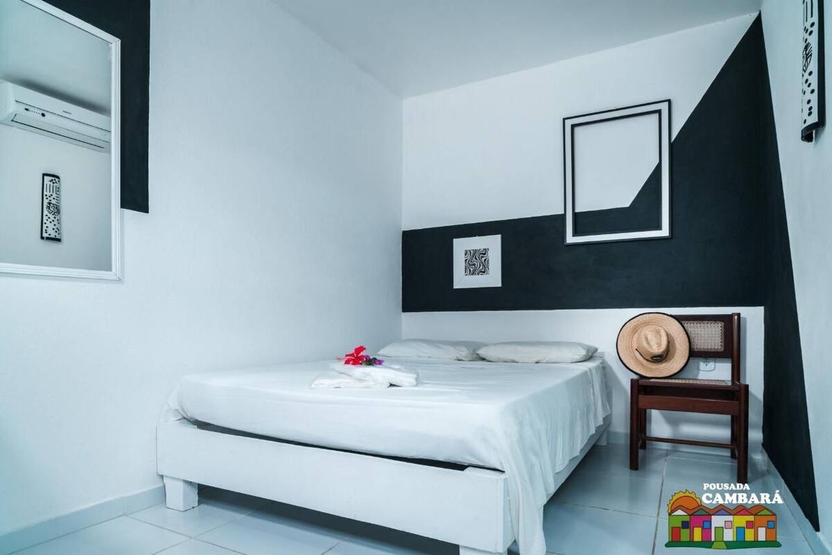 Une chambre à coucher avec un lit, une chaise et un cadre photo fixé au mur.