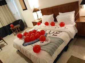 A hotel room with a neatly made bed, a bedside table with a lamp, and a chair. - Bianchi Hotel (Alexandria)