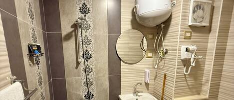Une salle de bain équipée d’une douche, d’un lavabo, de toilettes et d’un miroir.