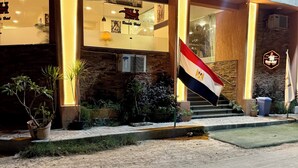 A hotel entrance with a flag, a staircase, and potted plants. - Bianchi Hotel (Alexandria)