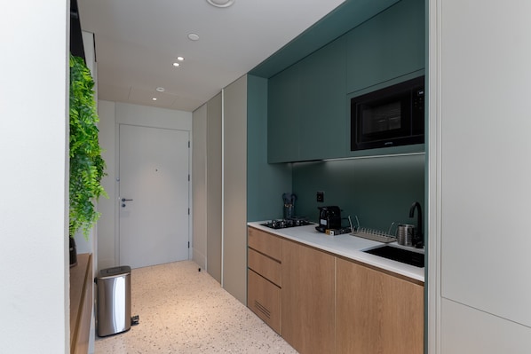 A modern kitchen with a microwave, coffee maker, and sink.