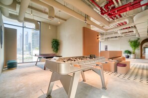 Relax in a spacious room with a foosball table, comfortable seating, and city views.