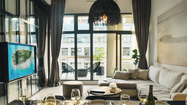 Un salon moderne doté d’une grande fenêtre, d’un canapé et d’un coin repas aménagé pour prendre un repas.