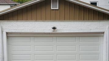 A garage with a white door, a wooden gable, and a small vent.