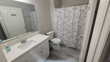 Combined shower/bathtub, towels, soap, toilet paper