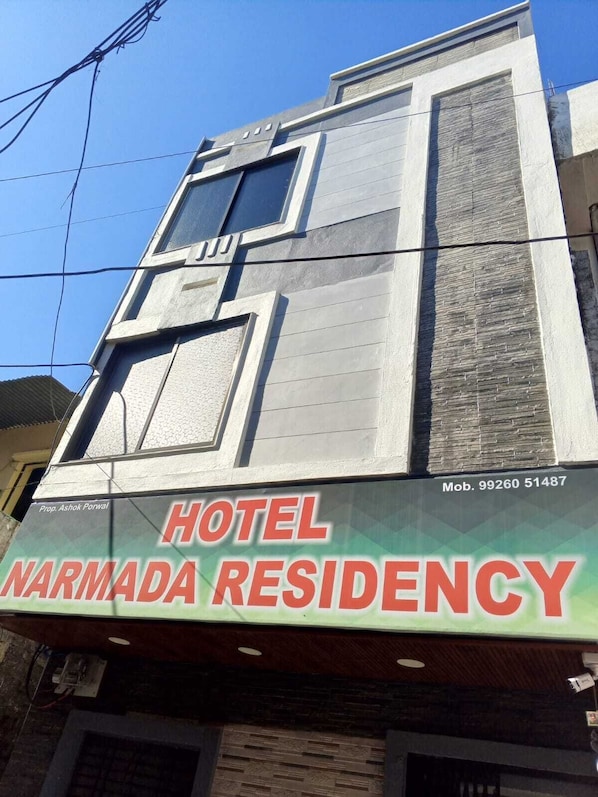 Un edificio con letrero que indica Hotel Narmada Residency.