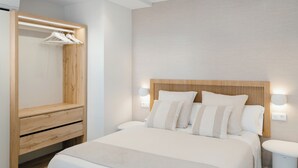 Ein modernes Schlafzimmer mit einem hölzernen Kopfteil, einem Nachttisch, einem Einbauschrank und einer Nachttischlampe.