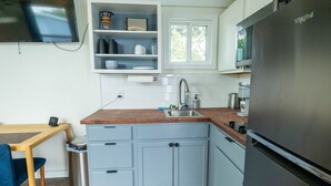 A compact kitchen with a refrigerator, sink, and a coffee maker. - Modern Tiny Home 15 mins from Fort Worth (Fort Worth)