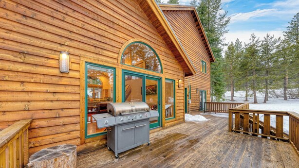 A wooden cabin with a deck, a grill, and a large window. - 5 Mins to Ski Resort Ping Pong, Pool Table, Deck Donner Ridge by Avantstay (Truckee)