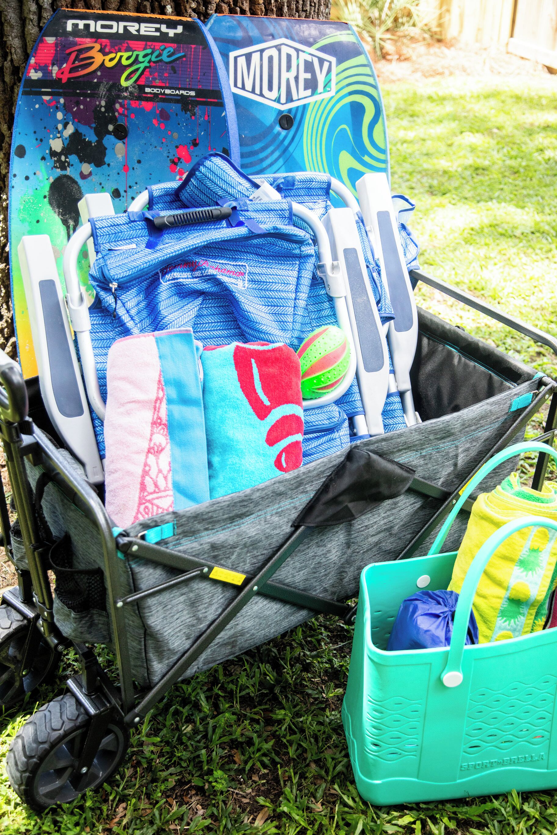 Un chariot contenant une planche de surf, des serviettes et un sac.