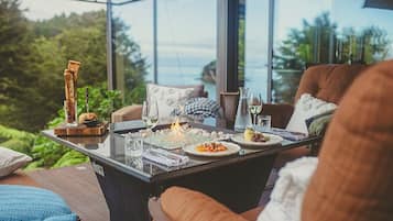 A dining table set with plates, glasses, and a candle.