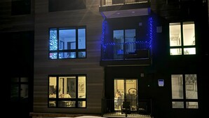 Ein mehrstöckiges Gebäude mit Balkon und überdachter Terrasse.