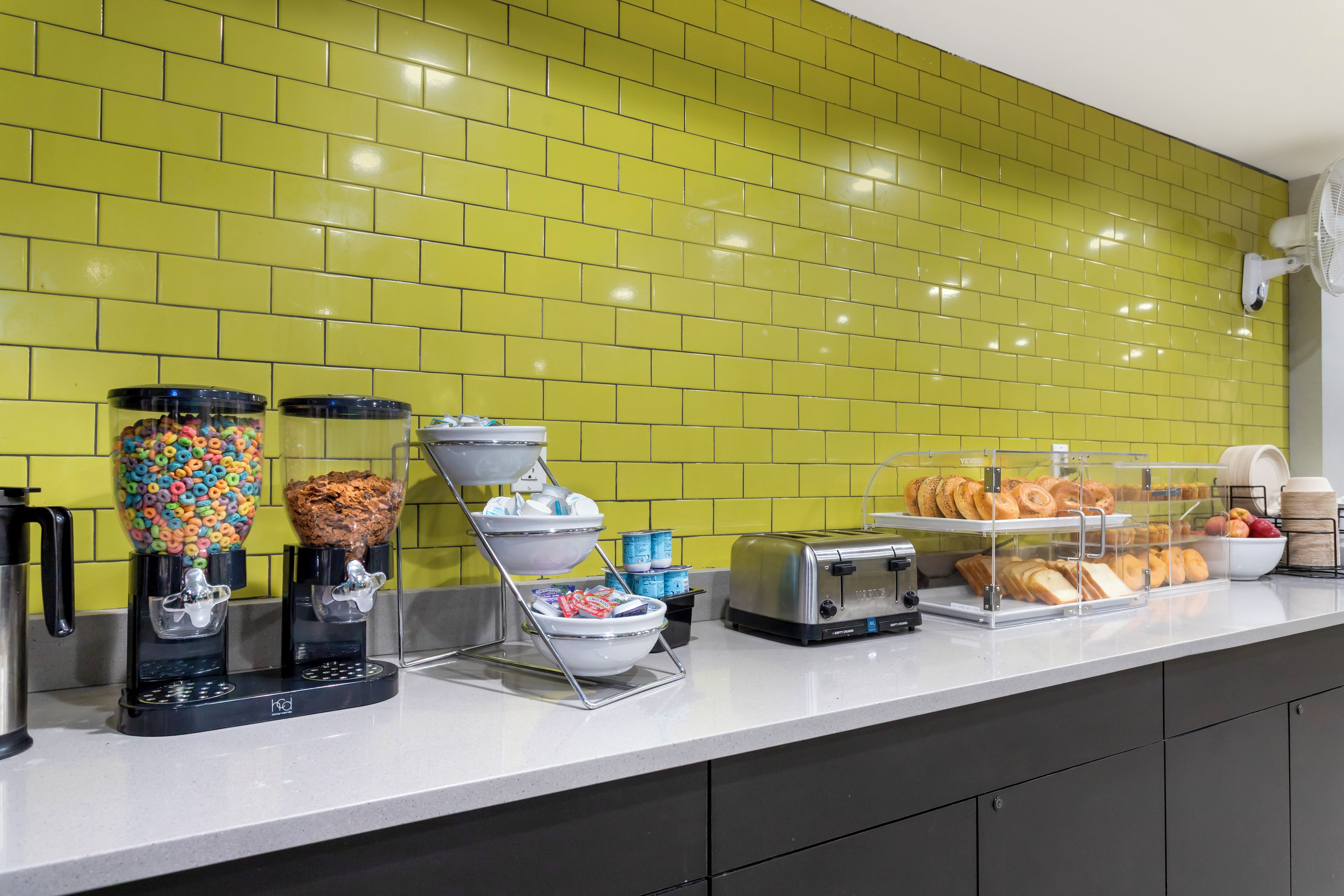 A breakfast bar with cereal dispensers, a coffee machine, and a toaster.