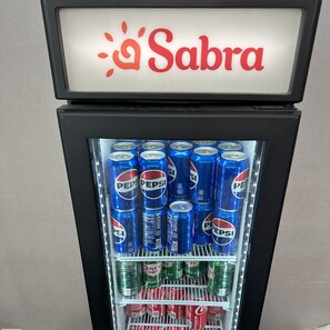En automater med et 'Sabra' skilt, fyldt med dåser af Pepsi og Canada Dry.