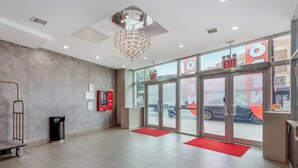 A spacious lobby with a chandelier, a red carpet, and an exit sign. - Red Roof PLUS+ Brooklyn - Flatbush Ave (Brooklyn)