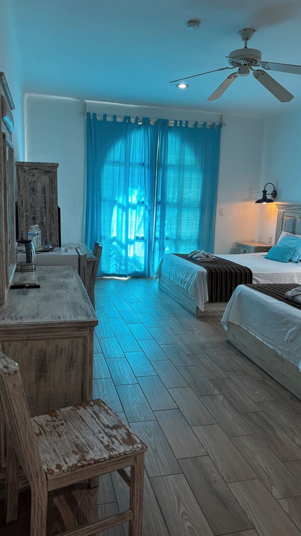 A bedroom with a bed, a desk, and a chair. - Coco Rio Hotel (Playa del Carmen)