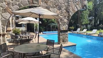 Een buitenzwembad en parasols bij het zwembad