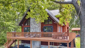Eine Holzhütte mit Steinuntergrund und einer Terrasse mit Sitzgelegenheiten im Freien.